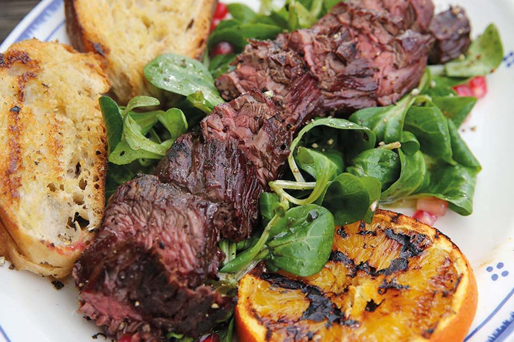 Hanging tender steak from the charcoal ball with pomegranate field salad 
