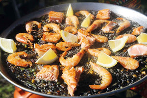 Paella negra mit Lachs und Garnelen