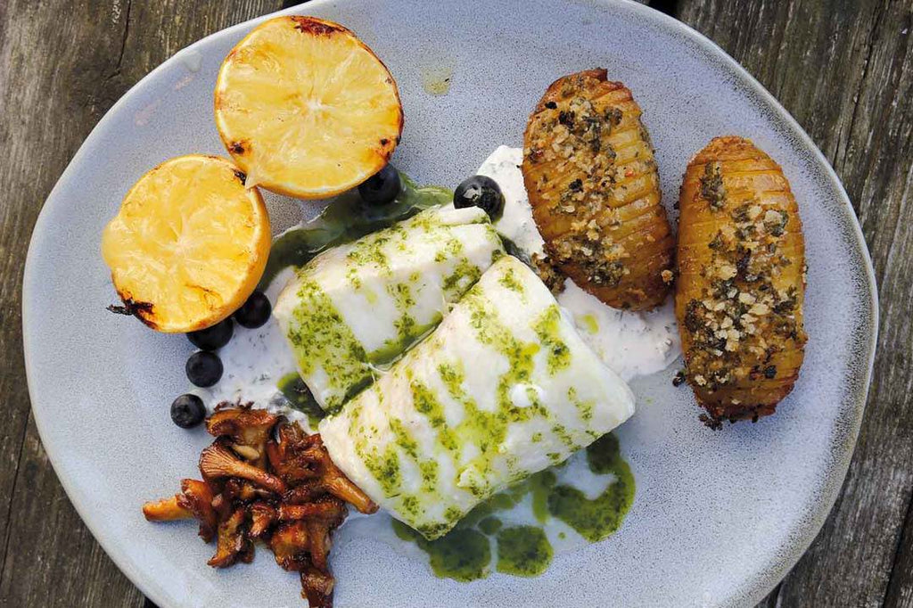Cod loins with horseradish cream, Hasselback potatoes, herb oil and sautéed chanterelles 