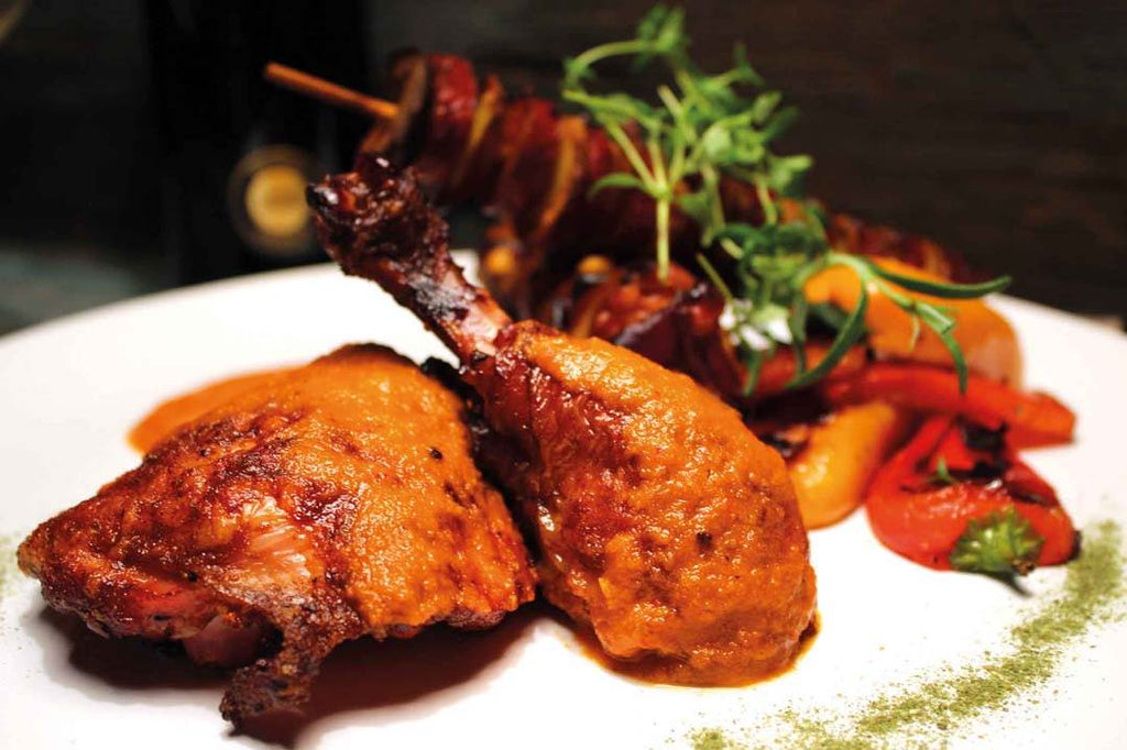 Canarian chicken leg in mojo roja with pinchos de patata and grilled peppers 